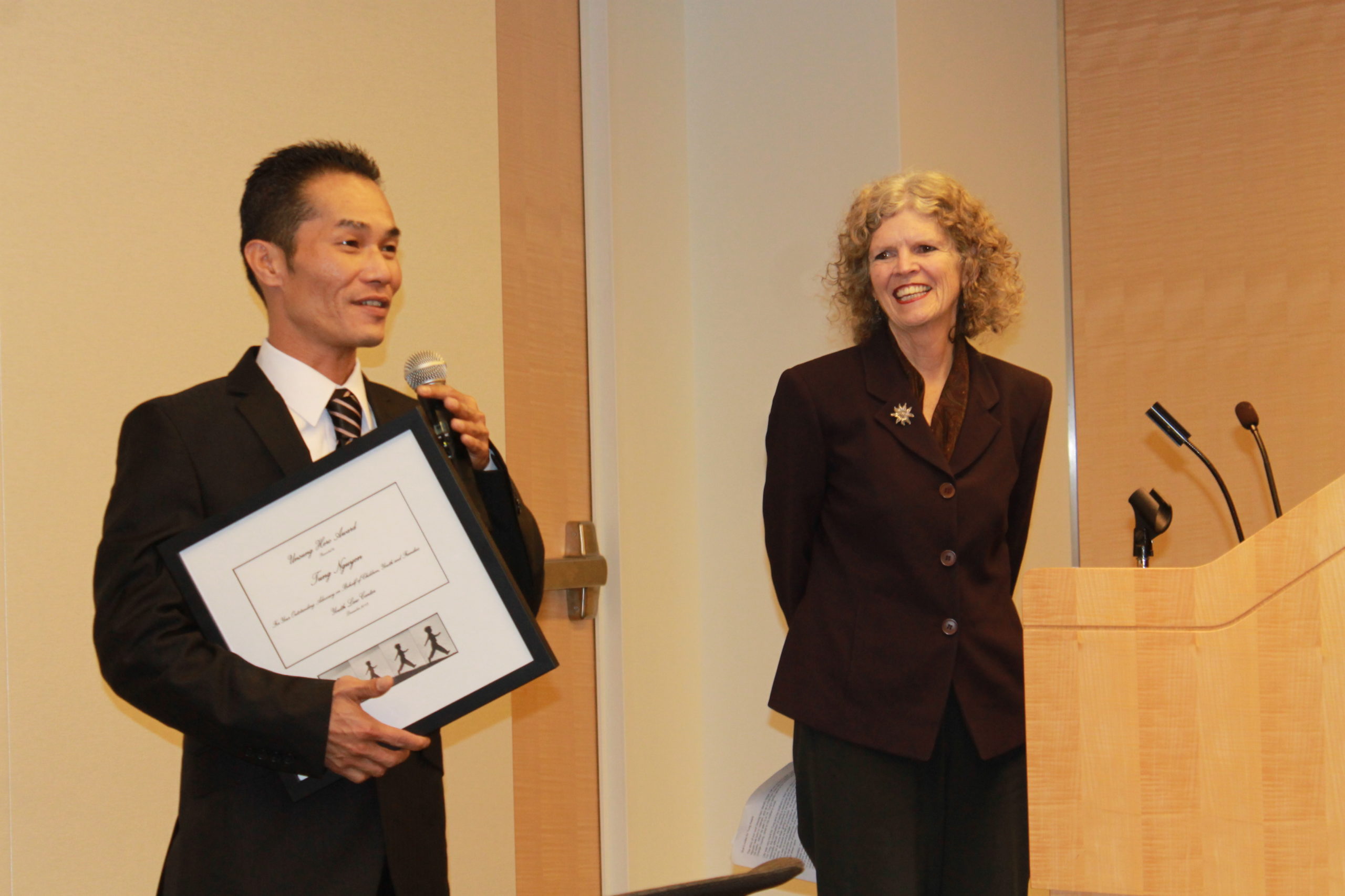 Photo of Sue Burrell presenting award to Tung Nguyen